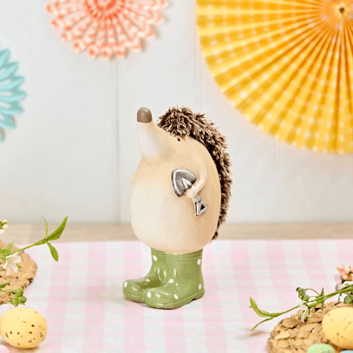 A garden hedgehog ornament wearing green polka dot boots.