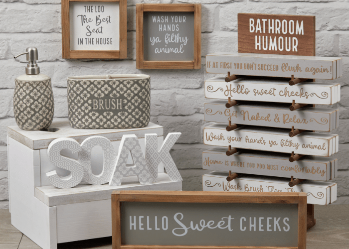 A range of unique gifts and decor for bathrooms, including signs, a soap dispenser and toothbrush holder.