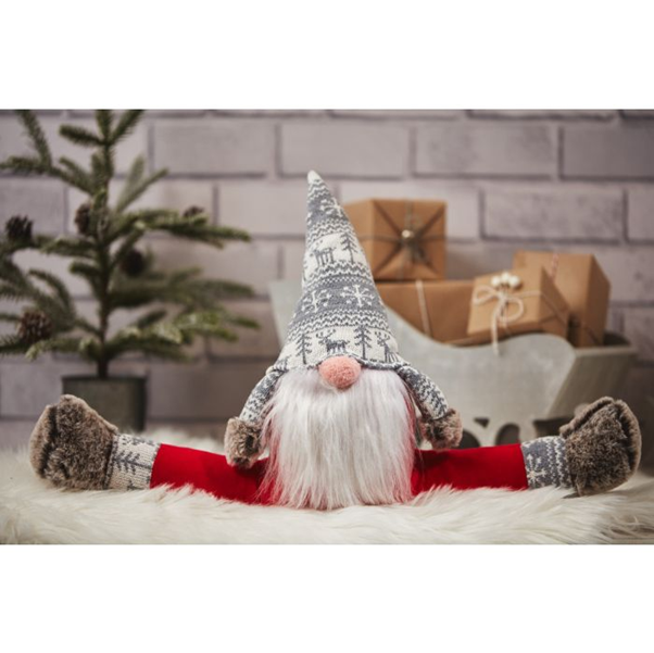 Festive soft toy gonk doorstop with long beard placed on floor to hold a door open in a cosy home setting. 