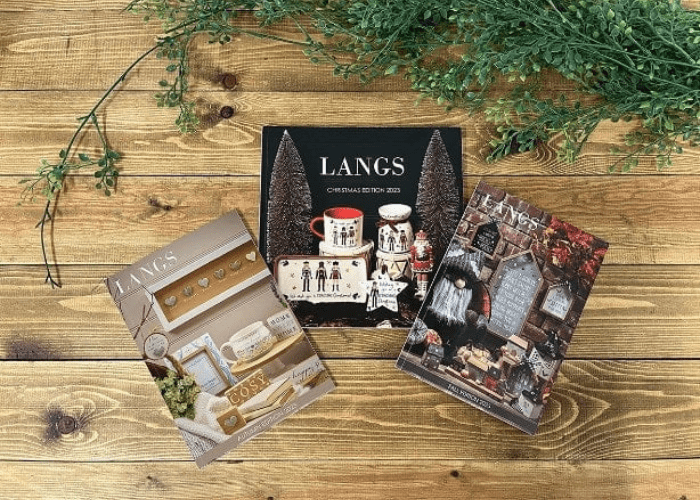 A collection of upcoming Langs autumn and fall catalogues displayed on a wooden background. 